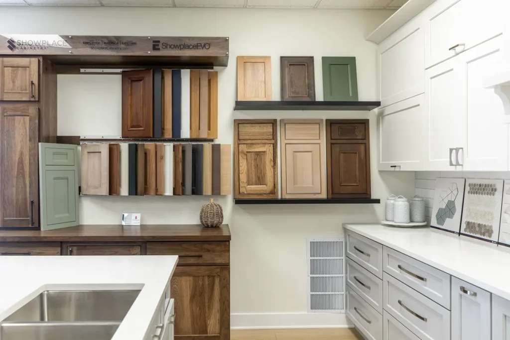The Showroom Page features various kitchen cabinet door samples in different colors and finishes displayed on the walls above white countertops and drawers.