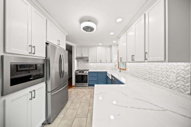A-modern-farmhouse-kitchen-with-white-and-blue-cabinets-and-farmhouse-sink